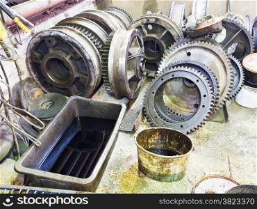 gears of disassembled engine on floor in mechanical workshop