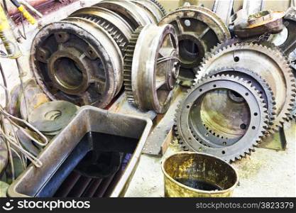gears of disassembled motor on floor in mechanical turnery