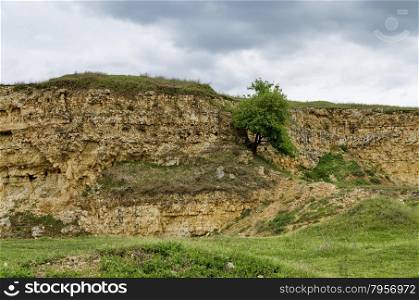 General view toward crag of sedimentary rock in the field, Ludogorie, Bulgaria
