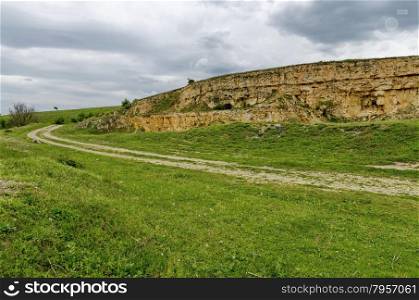 General view toward crag of sedimentary rock in the field, Ludogorie, Bulgaria