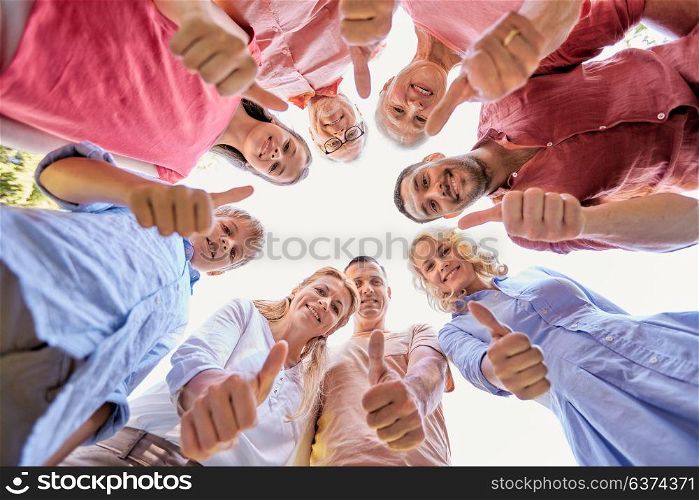 generation and people concept - happy family looking down standisg in circle and showing thumbs up. happy family showing thumbs up