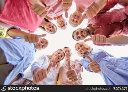 generation and people concept - happy family looking down standisg in circle and showing thumbs up. happy family showing thumbs up