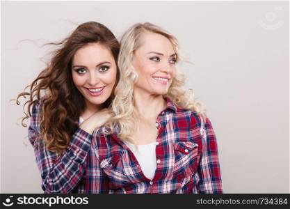 Generation and relationship. Portrait adult daughter with mother. Two gorgeous casual style women long hair blonde mom and brown haired girl, studio shot. Portrait adult daughter with mother.