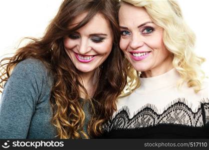 Generation relationship concept. Portrait adult daughter with mother. Two attractive elegant women, long curly hair blonde mom and brown haired girl. Adult mother and daughter portrait