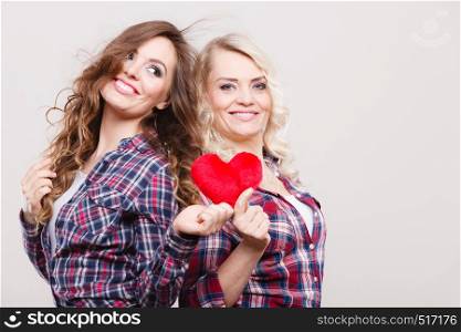 Generation relationship mother's day concept. Adult daughter and mother posing with red heart shape love symbol. Two cheerful casual style women. adult daughter and mother with heart love sign