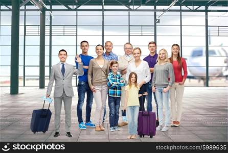 generation, travel, tourism and people concept - group of smiling people with luggage over airport terminal background