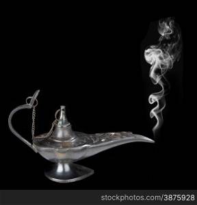 Genie lamp with a smoke - symbol of the rapid success. Isolated on black