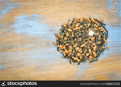genmaicha green tea with roasted rice, a pile against grunge wood with a copy space