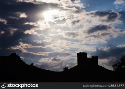 Genoese fortress silhouette with blue sky and clouds at sunset&#xA;