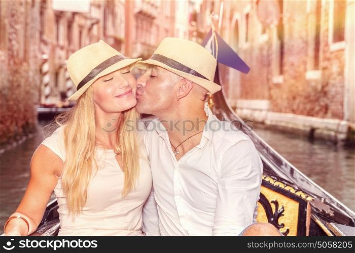 Gentle couple in love, newlywed husband kissing his beautiful young wife in gondola on the water in Venice, romantic relationship, enjoying honeymoon in Italy, Europe