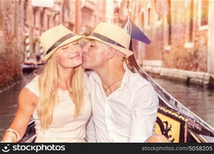 Gentle couple in love, newlywed husband kissing his beautiful young wife in gondola on the water in Venice, romantic relationship, enjoying honeymoon in Italy, Europe