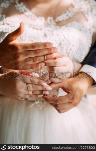 Gentle embrace of the hands of the newlyweds.. Sunny photo of the newlyweds holding hands 3912.