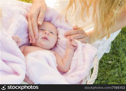 Gentle Hands of Mother Caressing Her Newborn Baby Girl in Pink Blanket.