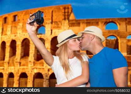 Gentle loving couple kissing and taking picture of themselves near beautiful gorgeous ancient Coliseum, honeymoon vacation in Rome, Italy, Europe