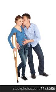 Gentle man cheer up his injured girlfriend using crutch to walk isolated on white