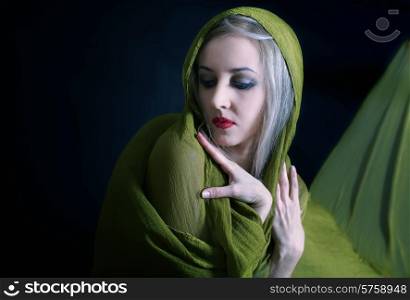 Gentle studio portrait of beautiful young woman in green summer dress