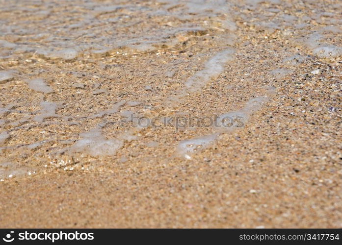 gentle water just comes over the sand. beach close up