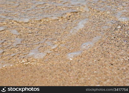 gentle water just comes over the sand. beach close up