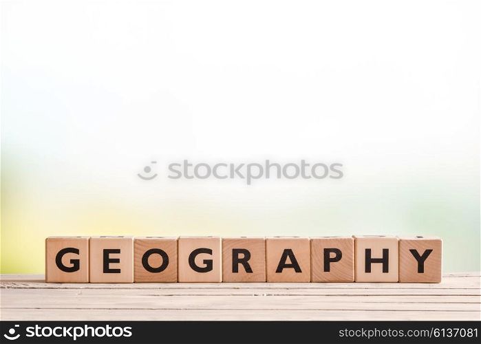 Geography lesson sign made of cubes on a wooden desk