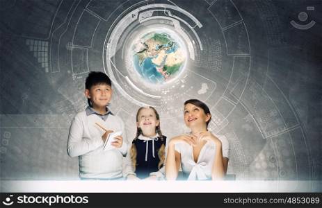 Geography lesson. Young teacher and her pupils examining Earth planet. Elements of this image are furnished by NASA