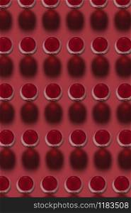 Geometric pattern from glasses with red wine alcoholic drink on a red background with hard shadows. Top view.. Red wine glasses pattern with hard dark shadows.