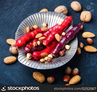 Georgian national delicacy. Turkish churchkhela with almonds and hazelnuts on slate table