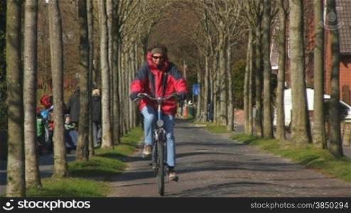 Gepflasterte Allee mit Fahrradfahrer auf der Insel Borkum