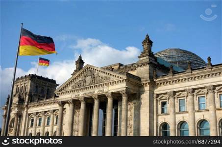 German flag waving at Bundestag building in Berlin Germany in a sunny day with blue sky.