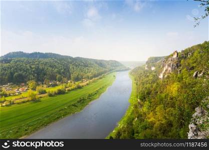Germany, provincial town in green forest on Elbe river, view from mountain. Buildings in old european style, German architecture. Germany, town on Elbe river, view from mountain