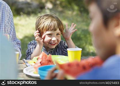 Gesticulating little boy at picnic