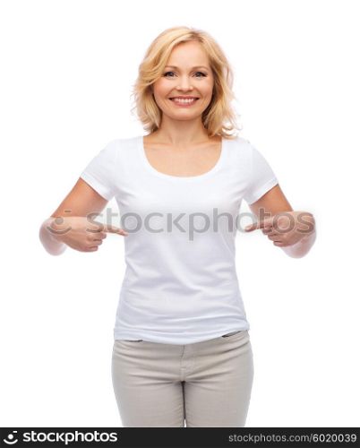 gesture, advertisement and people concept - smiling middle aged woman in blank white t-shirt pointing finger to herself