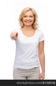 gesture, advertisement and people concept - smiling woman in blank white t-shirt pointing finger to you
