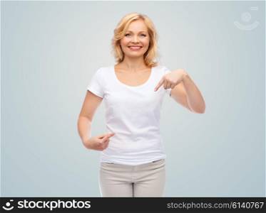 gesture, advertisement and people concept - smiling woman in blank white t-shirt pointing finger to herself over gray background