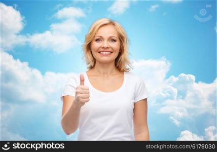 gesture, advertisement and people concept - smiling woman in blank white t-shirt showing thumbs up over blue sky and clouds background