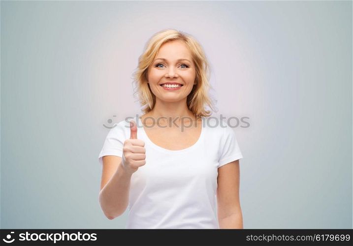 gesture, advertisement and people concept - smiling woman in blank white t-shirt showing thumbs up over gray background