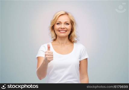 gesture, advertisement and people concept - smiling woman in blank white t-shirt showing thumbs up over gray background
