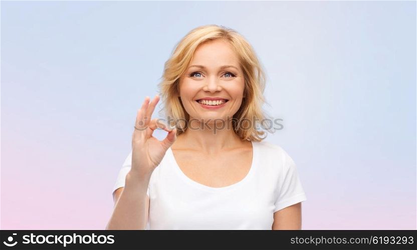 gesture, advertisement and people concept - smiling woman in blank white t-shirt showing ok hand sign over rose quartz and serenity gradient background