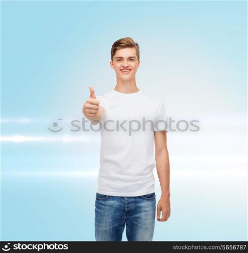 gesture, advertising and people concept - smiling young man in blank white t-shirt showing thumbs up over blue laser background