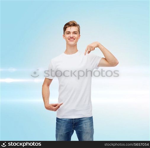 gesture, advertising and people concept - smiling young man in blank white t-shirt pointing fingers on himself over blue laser background