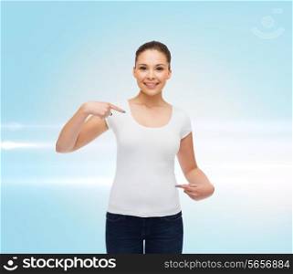 gesture, advertising and people concept - smiling young woman in blank white t-shirt pointing fingers on herself over blue laser background