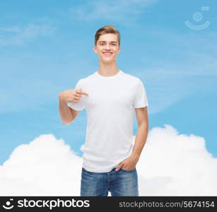 gesture, advertising, dream and people concept - smiling young man in blank white t-shirt pointing finger on himself over blue sky background