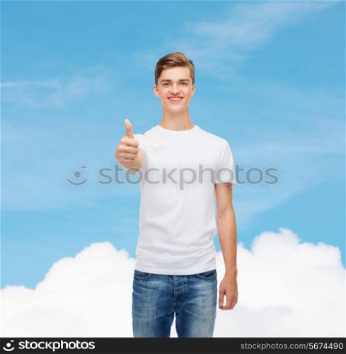 gesture, advertising, dream and people concept - smiling young man in blank white t-shirt showing thumbs up over blue sky background