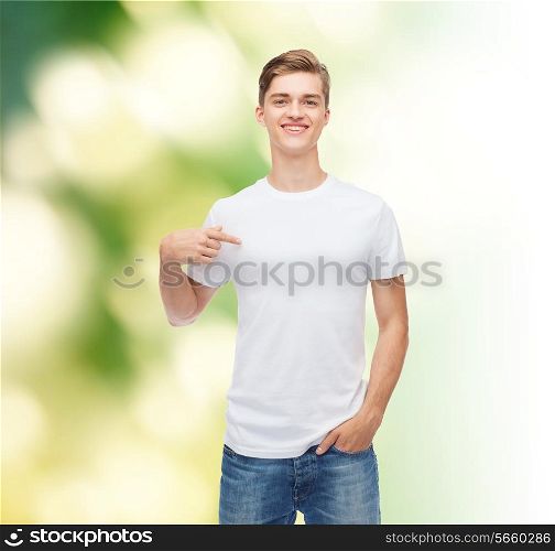 gesture, advertising, ecology and people concept - smiling young man in blank white t-shirt pointing finger on himself over green background