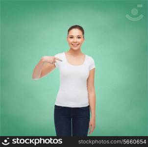 gesture, advertising, education, school and people concept - smiling young woman in blank white t-shirt pointing finger on herself over green board background