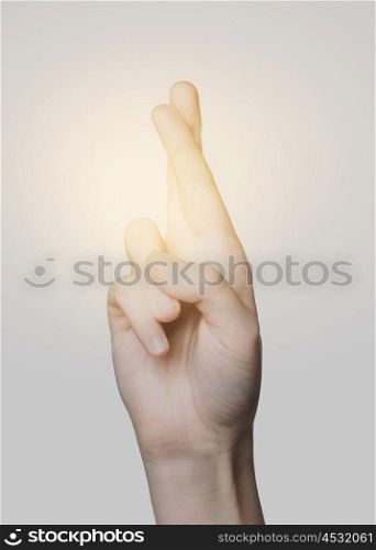 gesture and body parts concept - close up of hand showing two cross fingers. close up of hand showing two cross fingers
