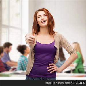 gesture and happy people concept - smiling girl in casual clothes showing thumbs up