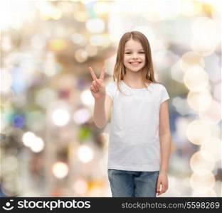 gesture and happy people concept - smiling little girl in white blank t-shirt showing peace gesture with fingers