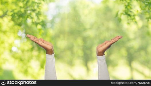 gesture and people concept - close up of african american woman clapping hands over green natural background. close up of african american woman clapping hands