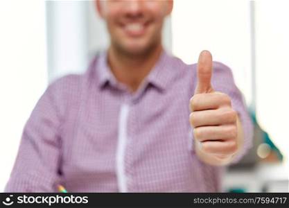 gesture and people concept - close up of happy young man showing thumbs up. happy young man showing thumbs up