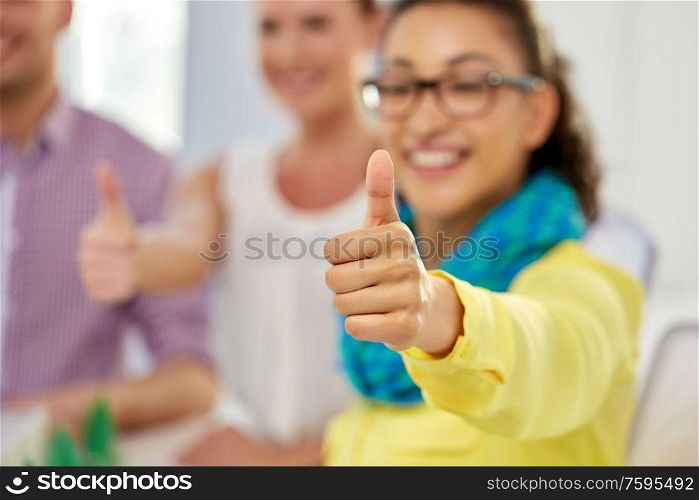 gesture and people concept - close up of happy young woman showing thumbs up. happy young woman showing thumbs up